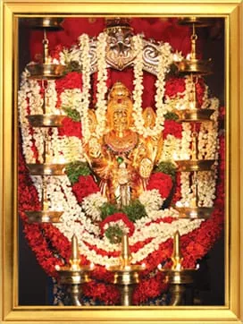 The Panchaloha idol of Sree Bhagavathy adorned with flower garlands and lamps